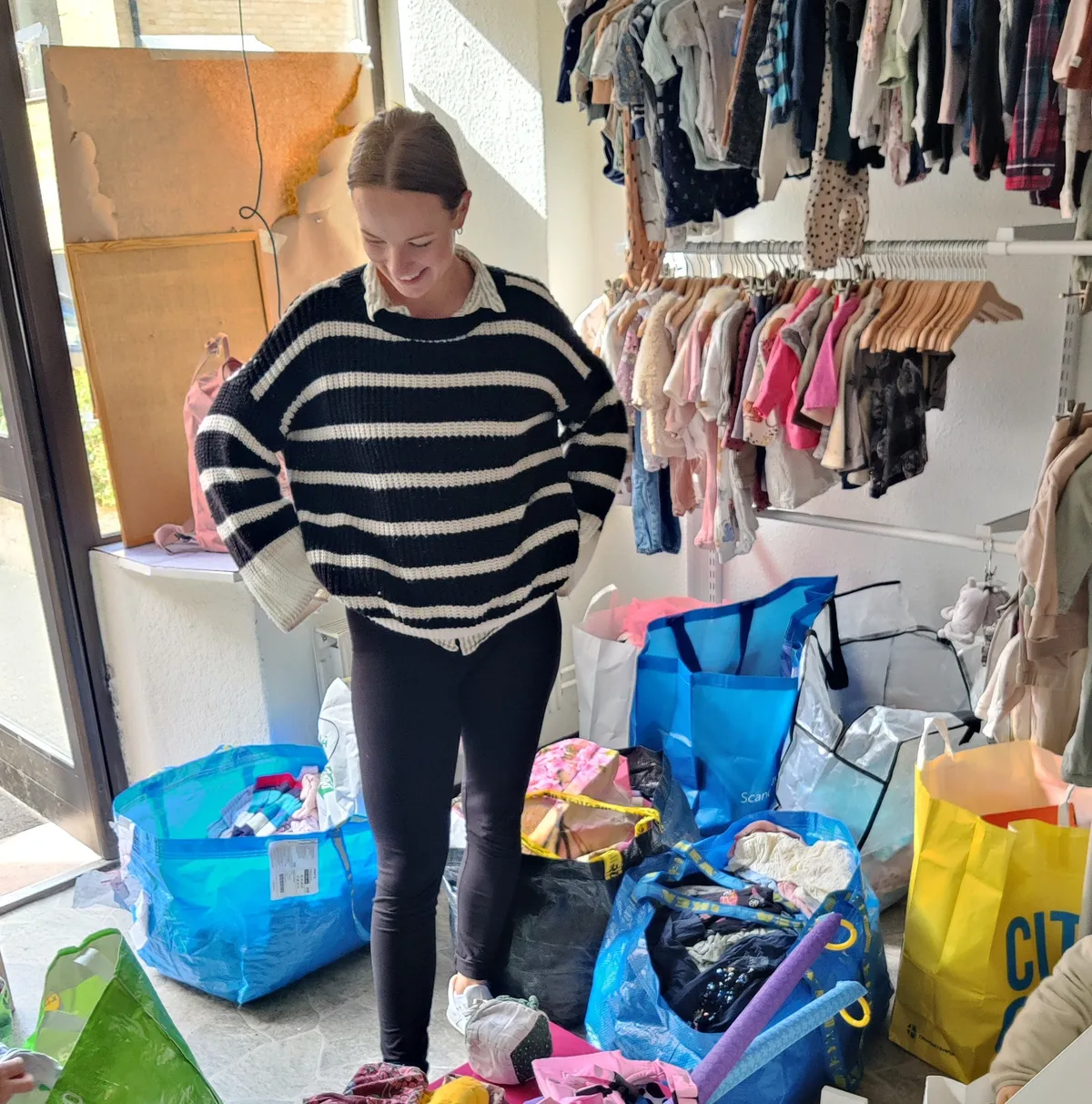 Butiksägare tar emot påsar med kläder i Lilleman & Jag